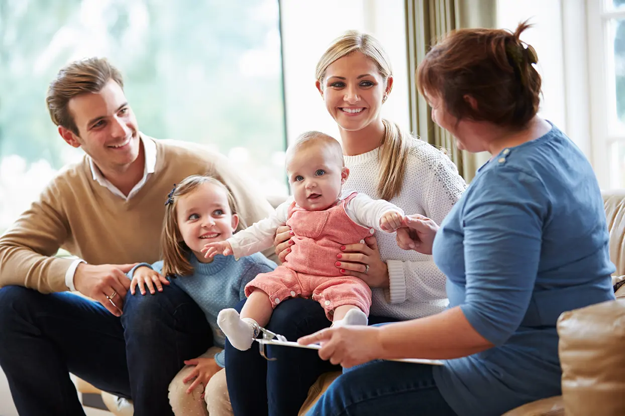 counselor talking with young couple and their two daughters