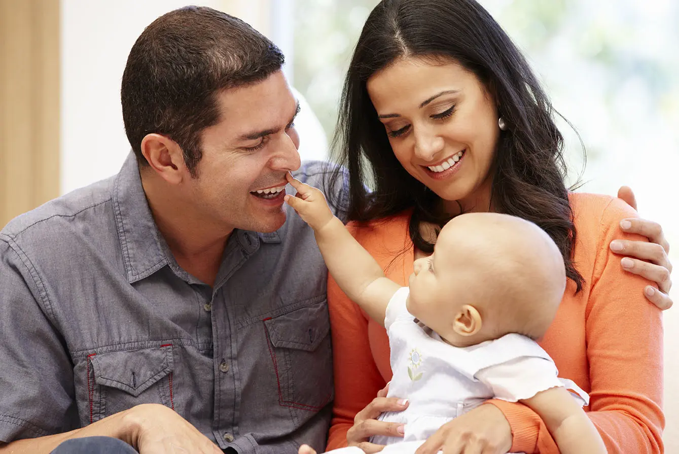 two young parents holding newborn baby