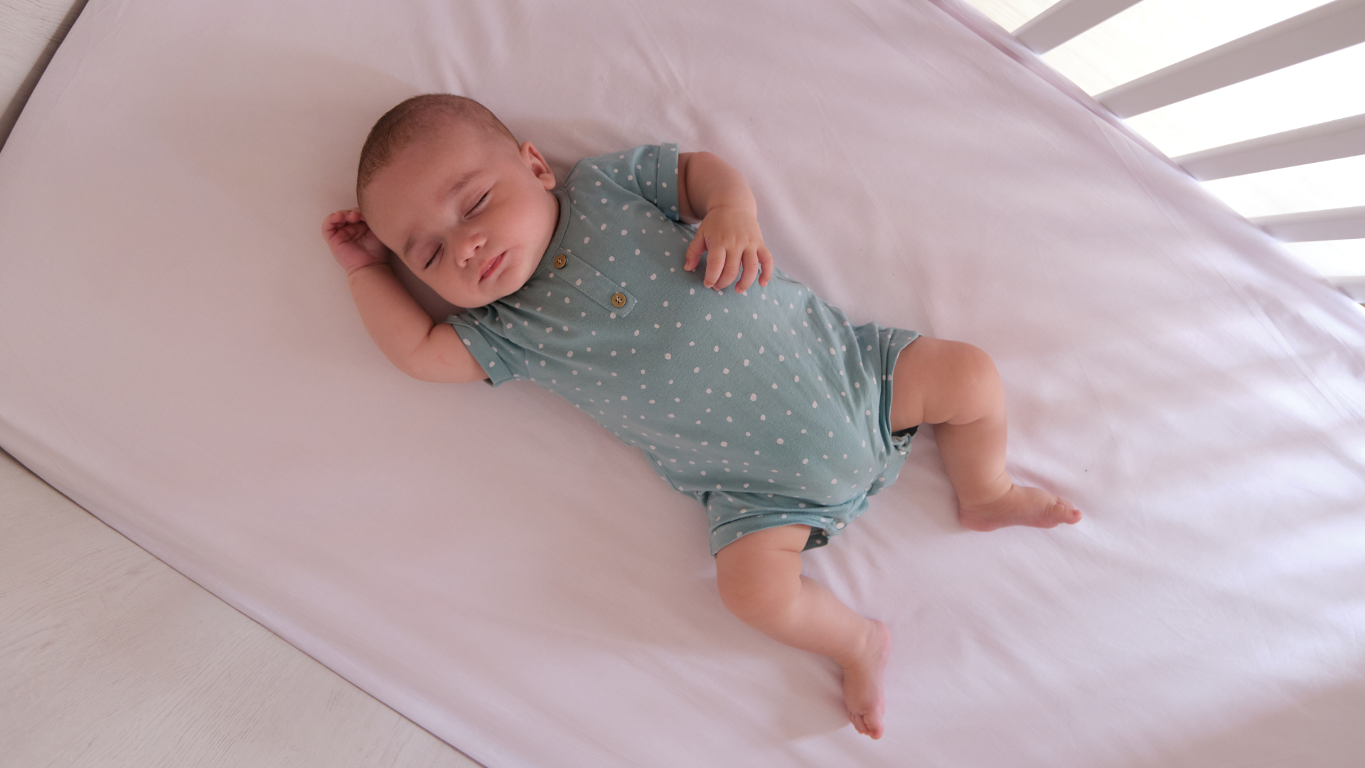 A baby is safely sleeping in a crib.
