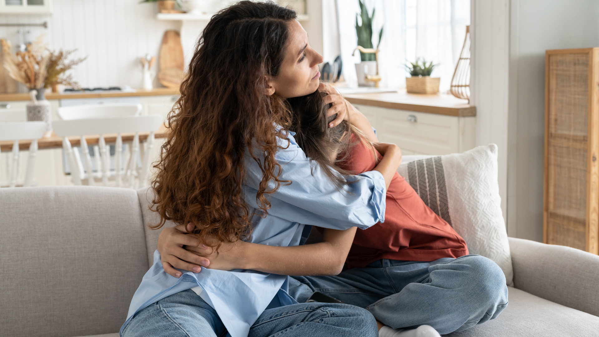 A parent comforts her teen, who has just admitted they struggle with substance use.
