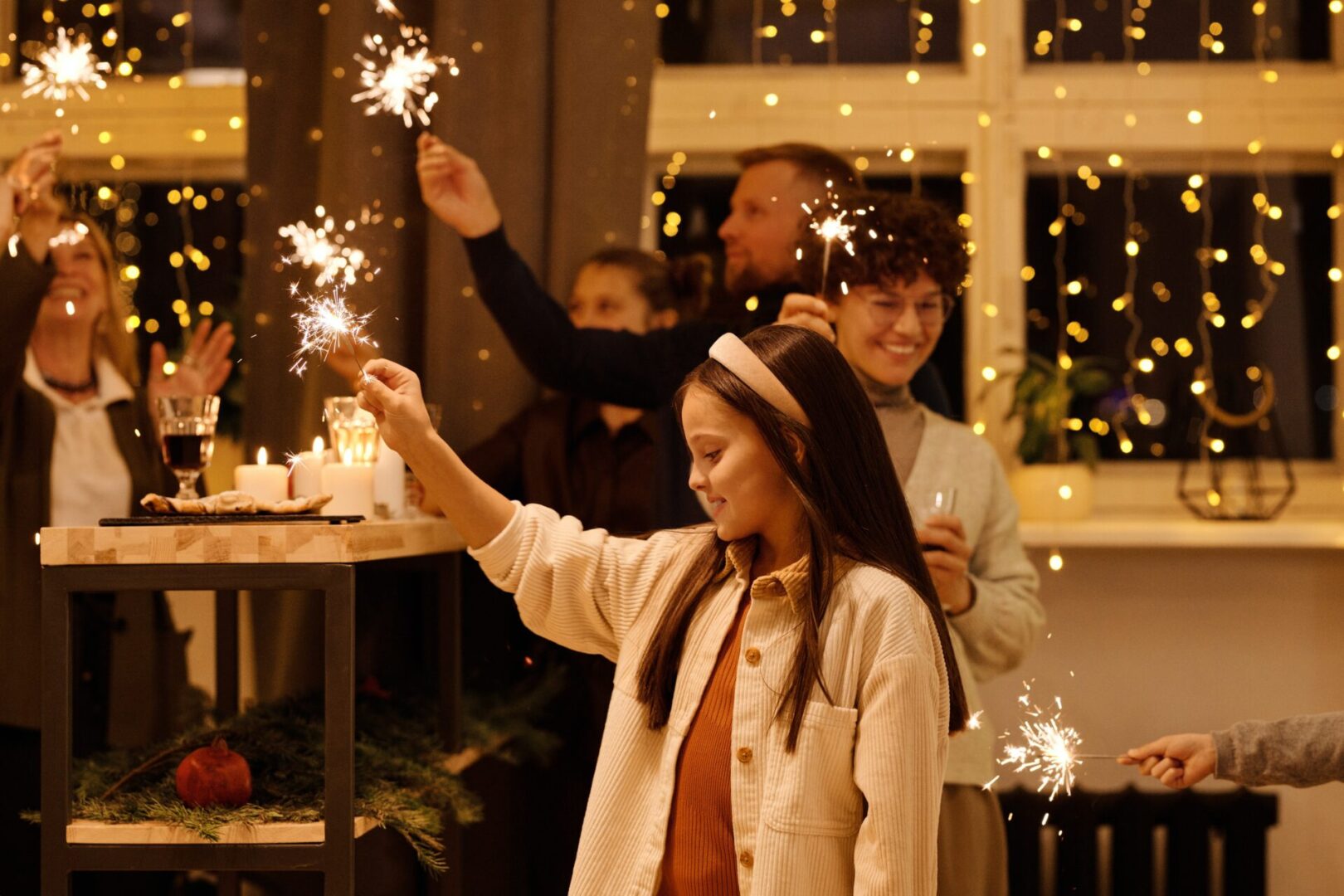 family members holding sparklers at holiday party