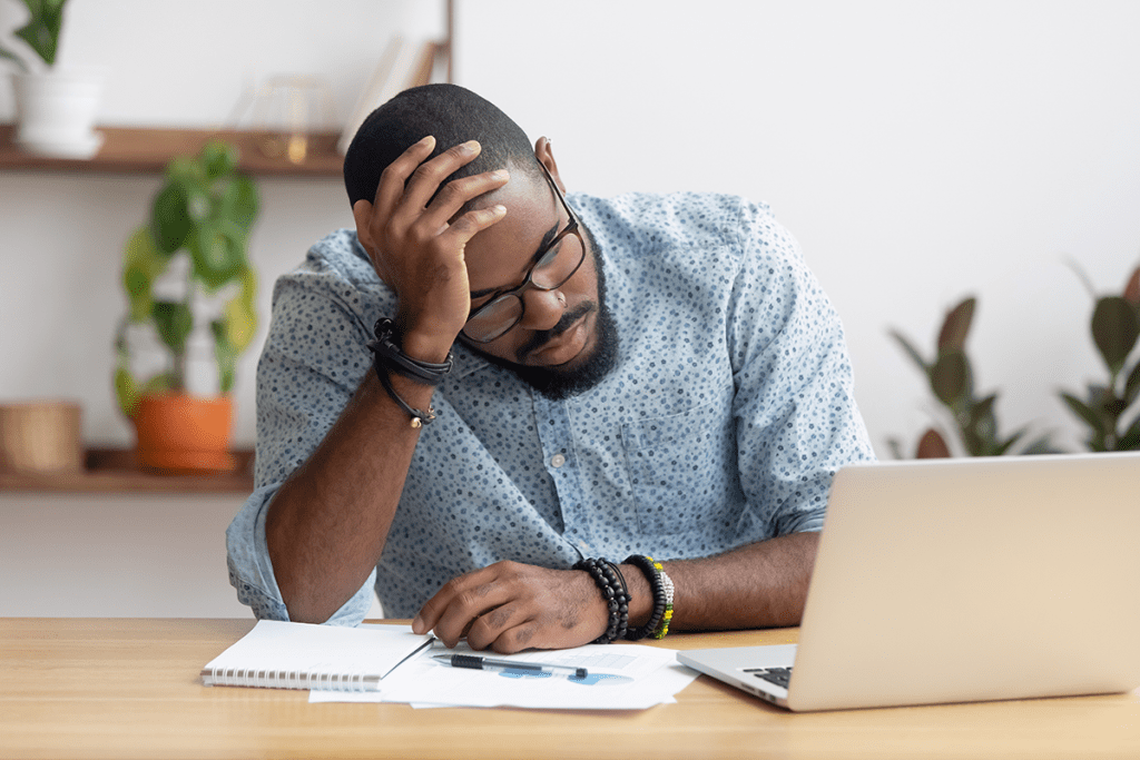 man experiencing burnout while working on laptop