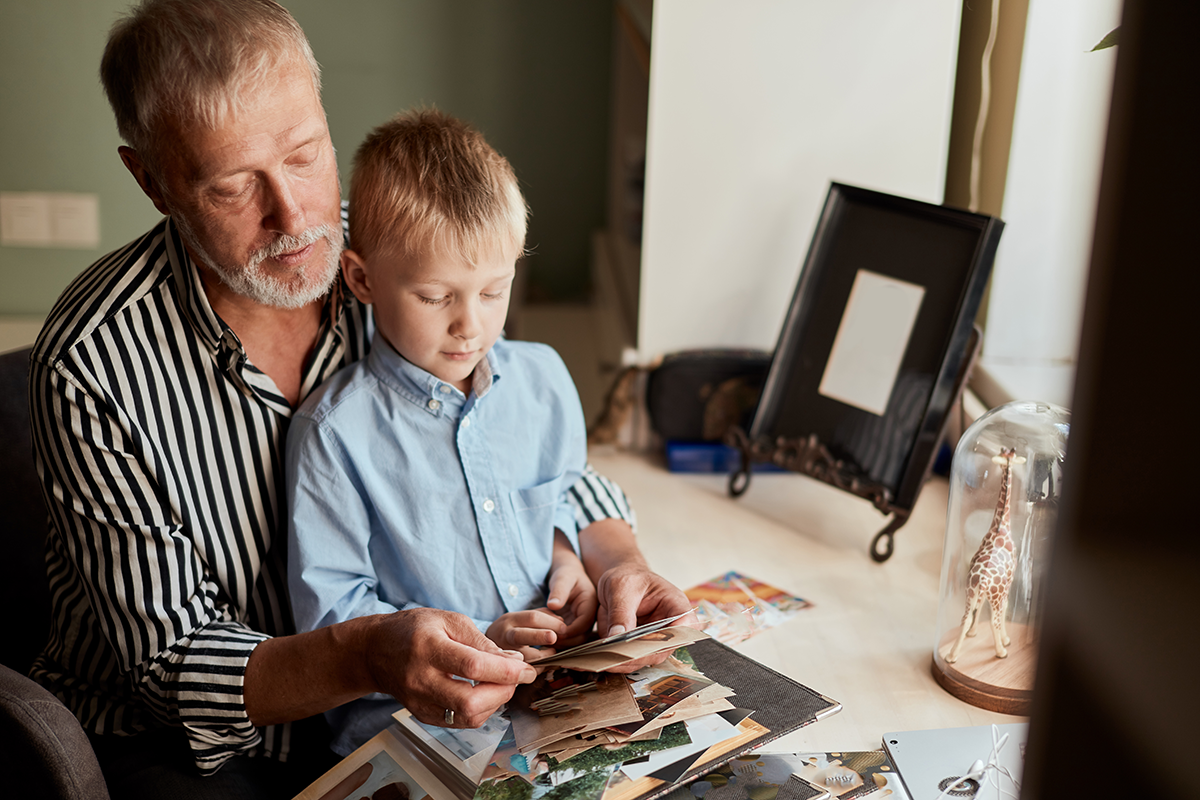 grandfather and grandson dealing with loss by making a family photo album together