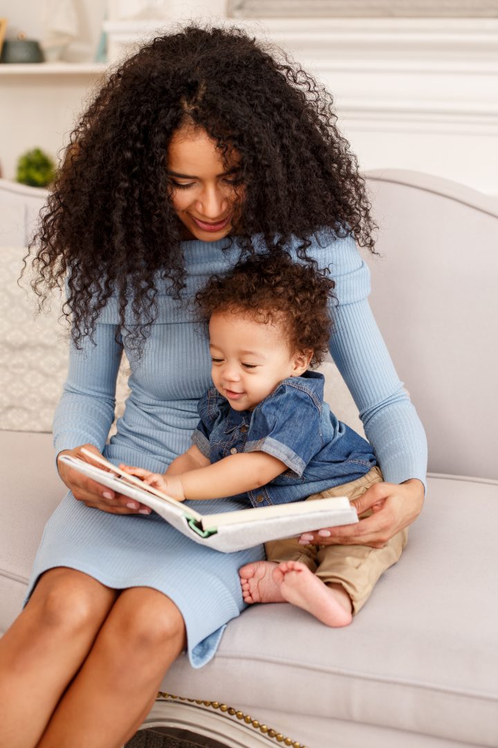 african american mother reading book to her infant son