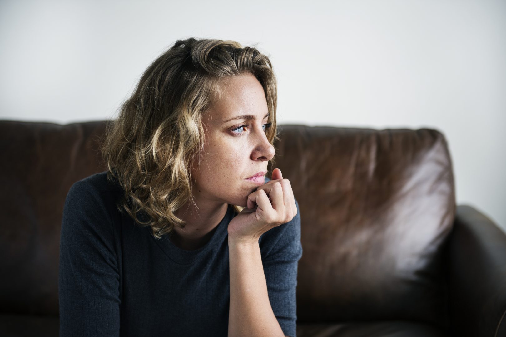 woman struggling with mental health issue sitting on the couch