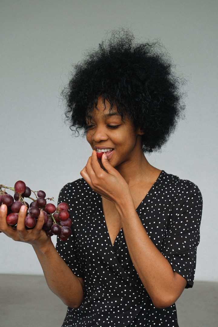 portrait of healthy woman eating grapes