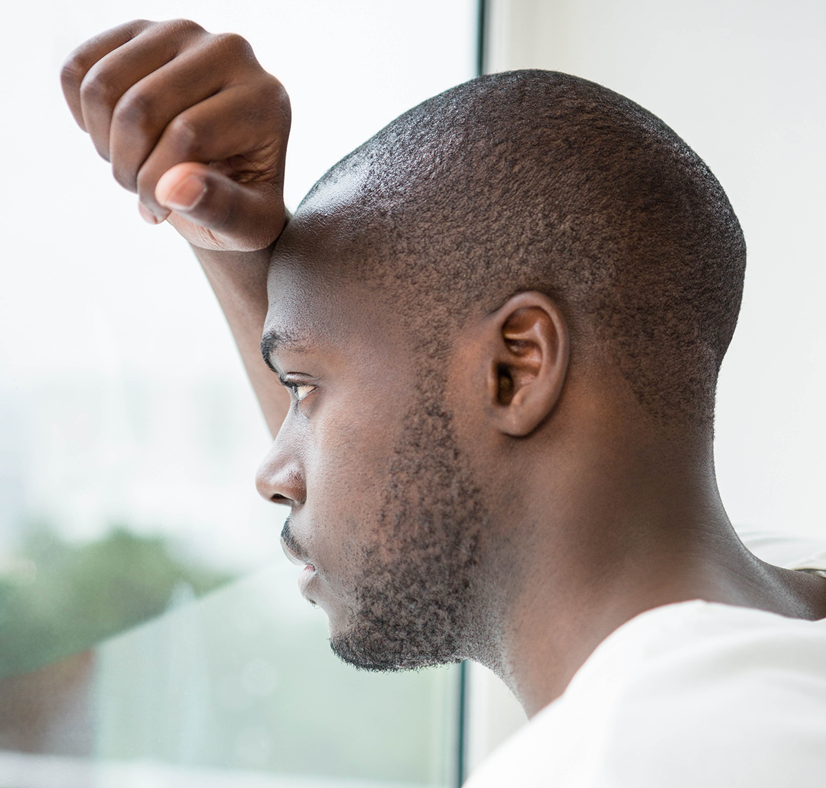 sad man looking out the window - men's health month