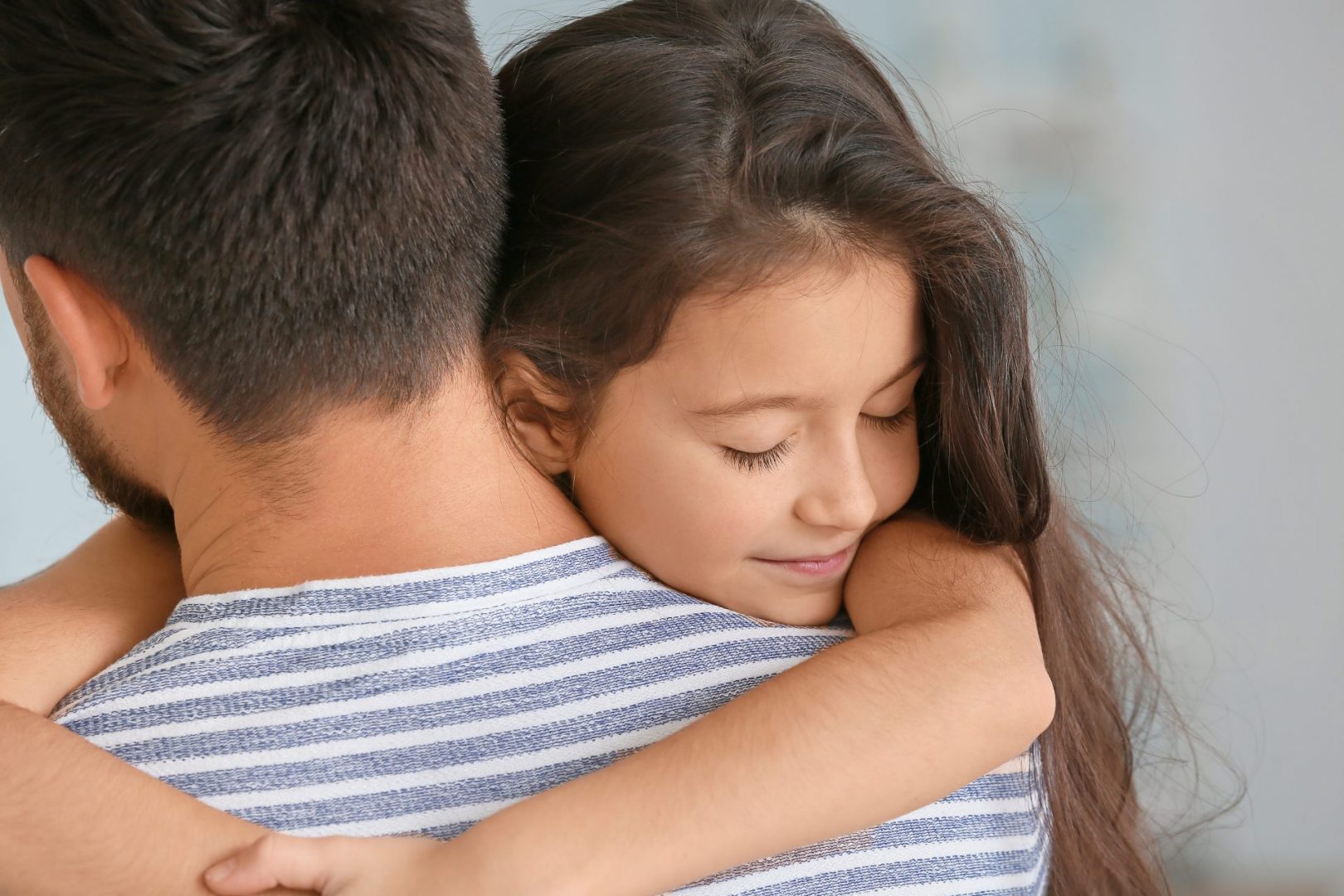 young girl in foster care hugging her foster father