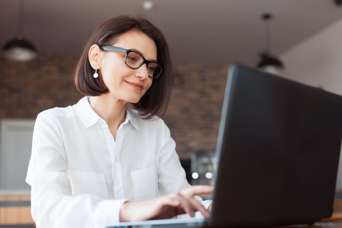 middle aged woman looking at computer screen