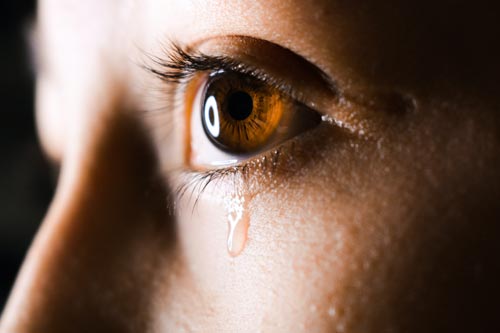 close up woman brown eye crying tear