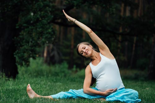 young woman pregnancy stretching