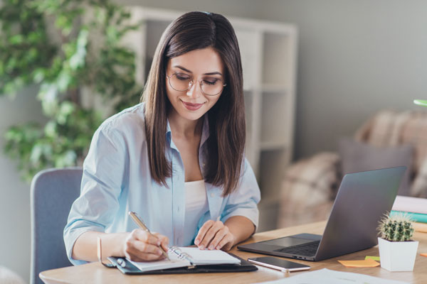 woman writing in planner routines