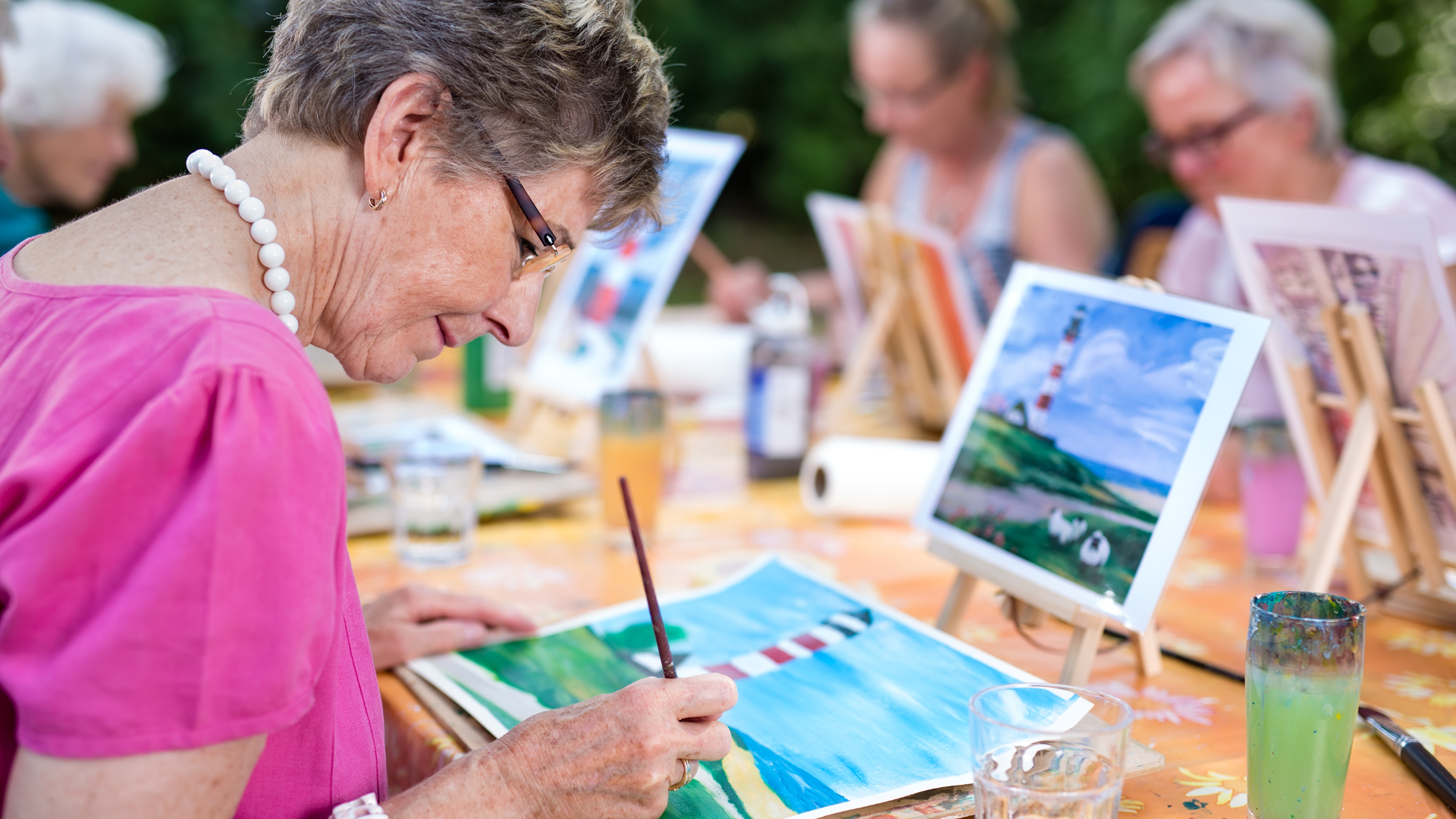 older woman participating in art therapy through painting