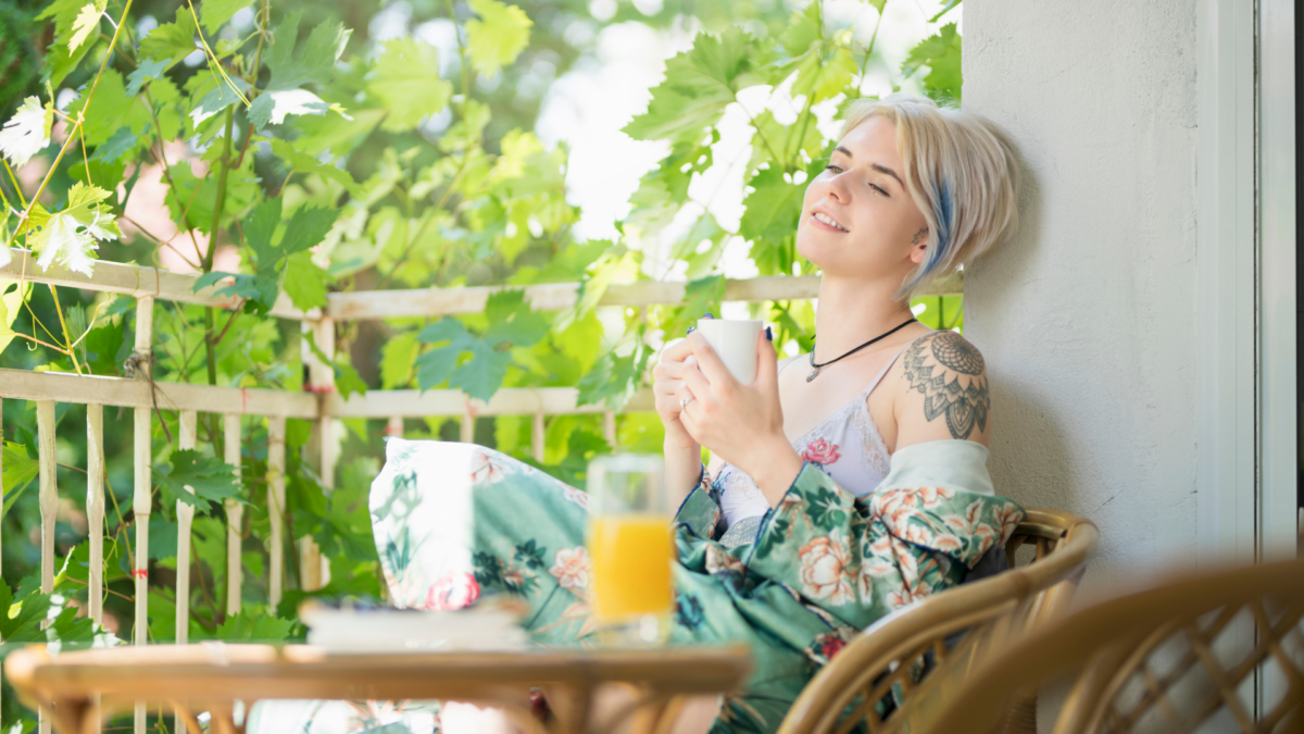 Woman relaxes on her porch in the sunlight, taking her "me time" outside.