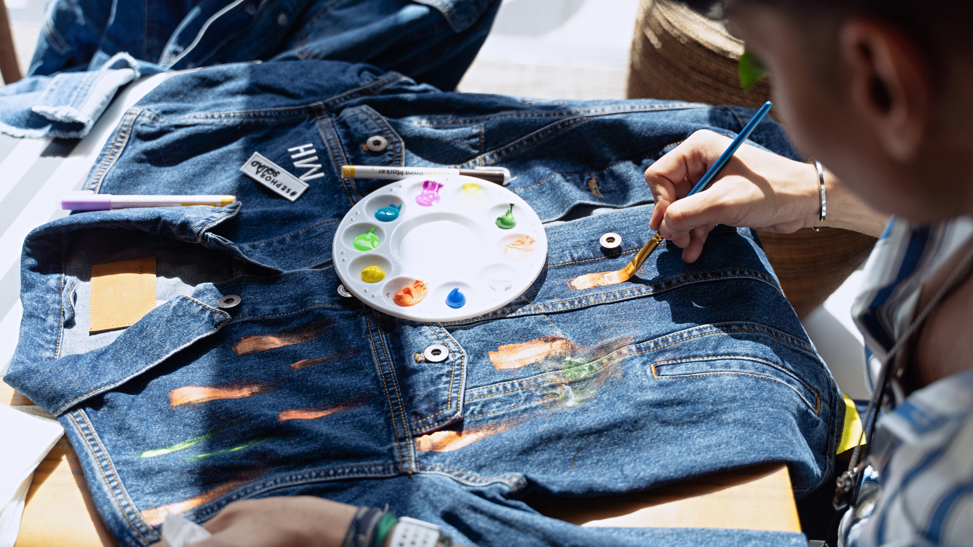 A woman upcycles a denim shirt to maintain mindful sustainability. 