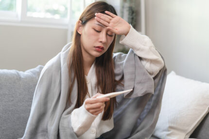 Woman measuring temperature because she is anxious about her health.