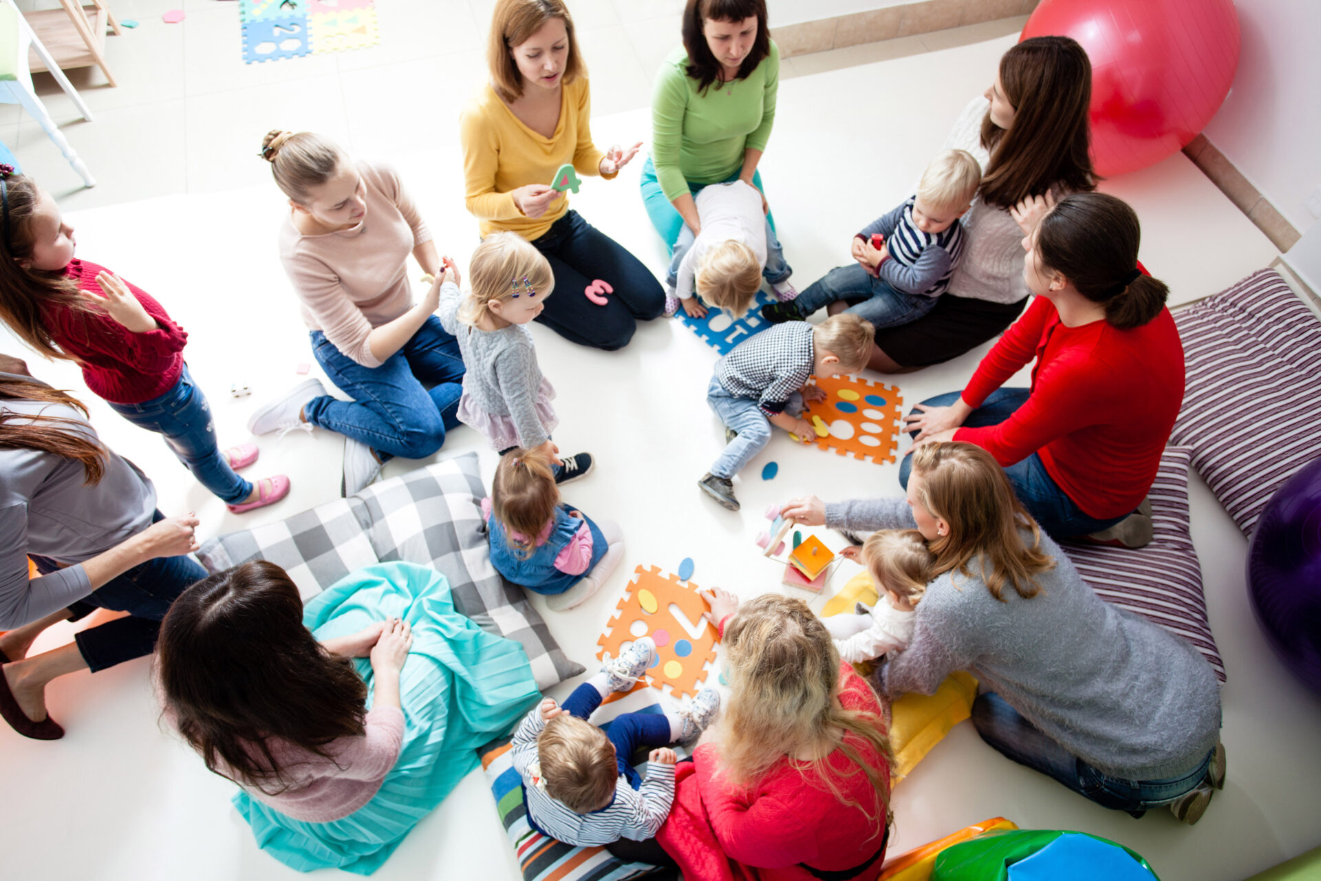 A group of moms with their young children, finding community through a local support group.